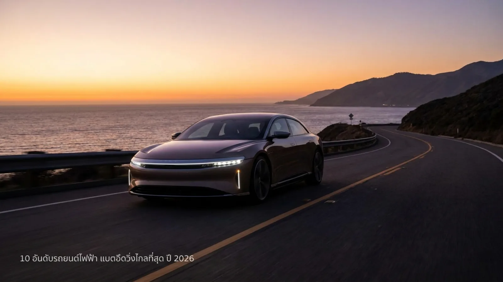 รถยนต์ไฟฟ้าดีไซน์สปอร์ตสีเงินกำลังขับขี่บนถนนเลียบชายฝั่งทะเลในช่วงพระอาทิตย์ตกดิน แสงสีทองสะท้อนเงาบนตัวรถอย่างสวยงาม